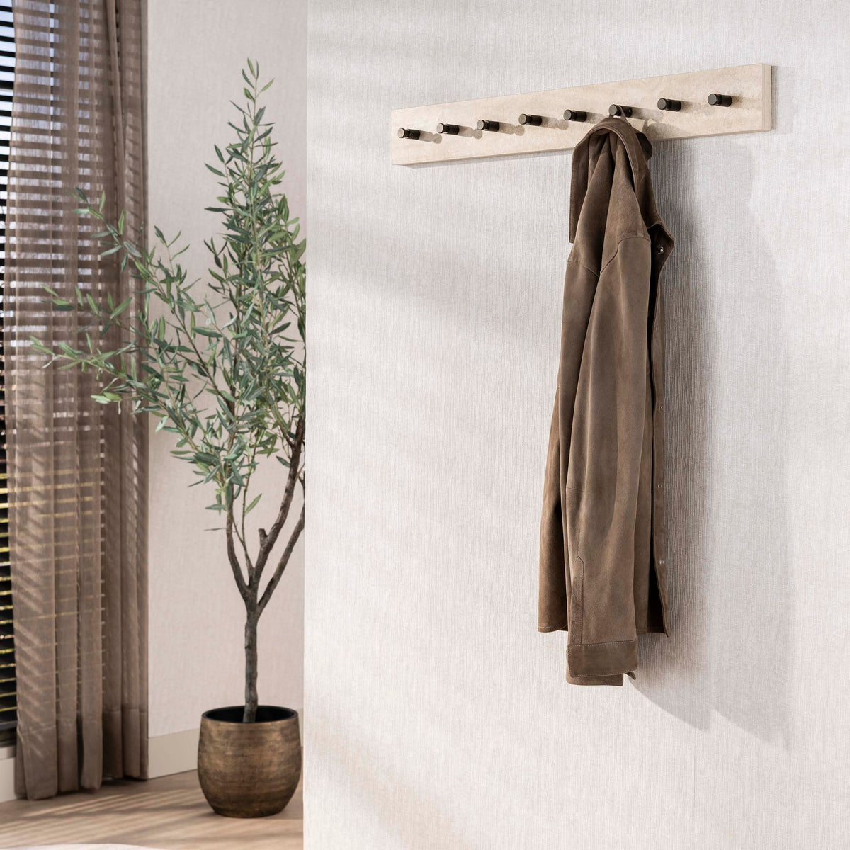 Kapstok Sava van Meubelista in beige: sfeerfoto met jas aan de wand.