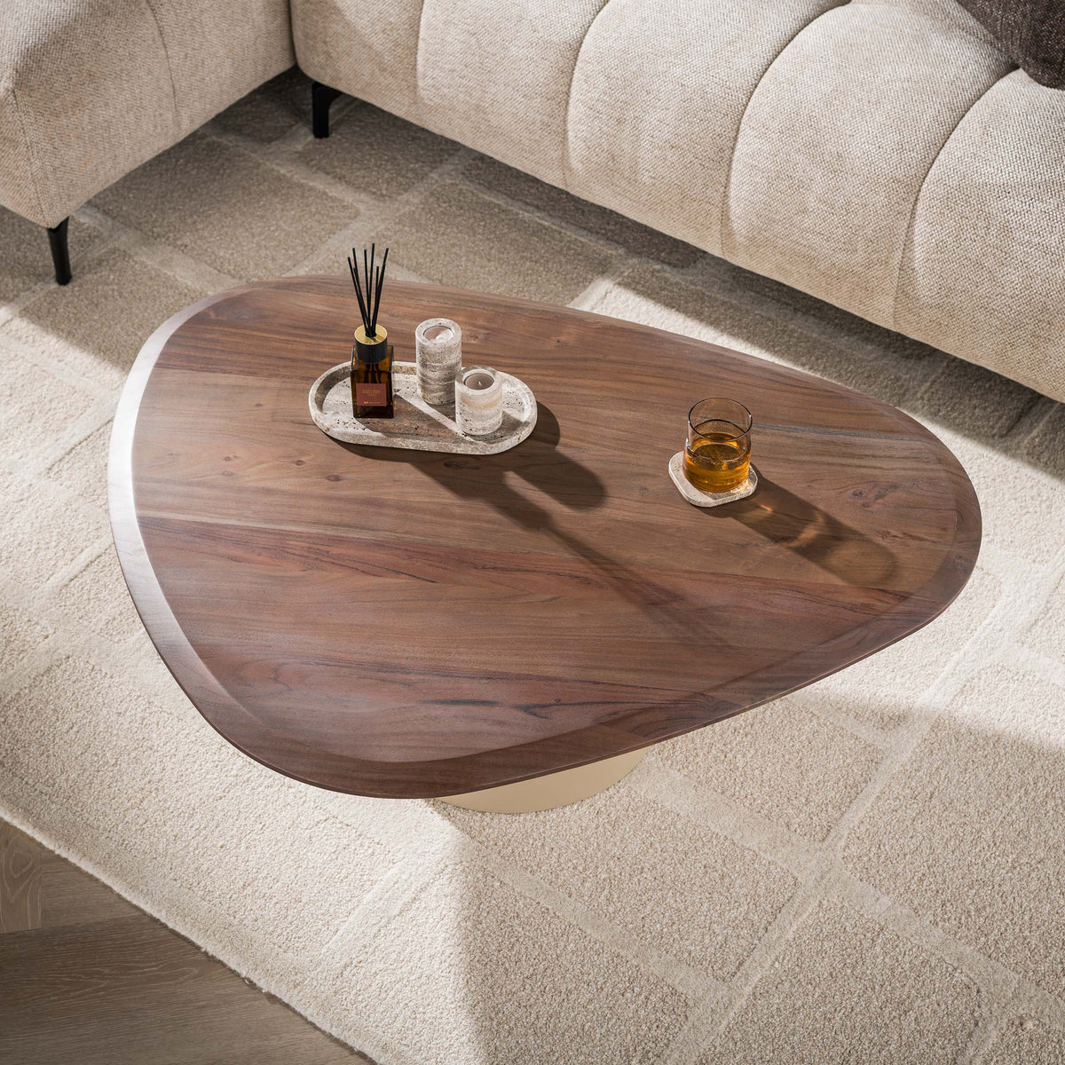 Salontafel Norell van Meubelista van boven gezien, met afgerond driehoekig blad en accessoires.