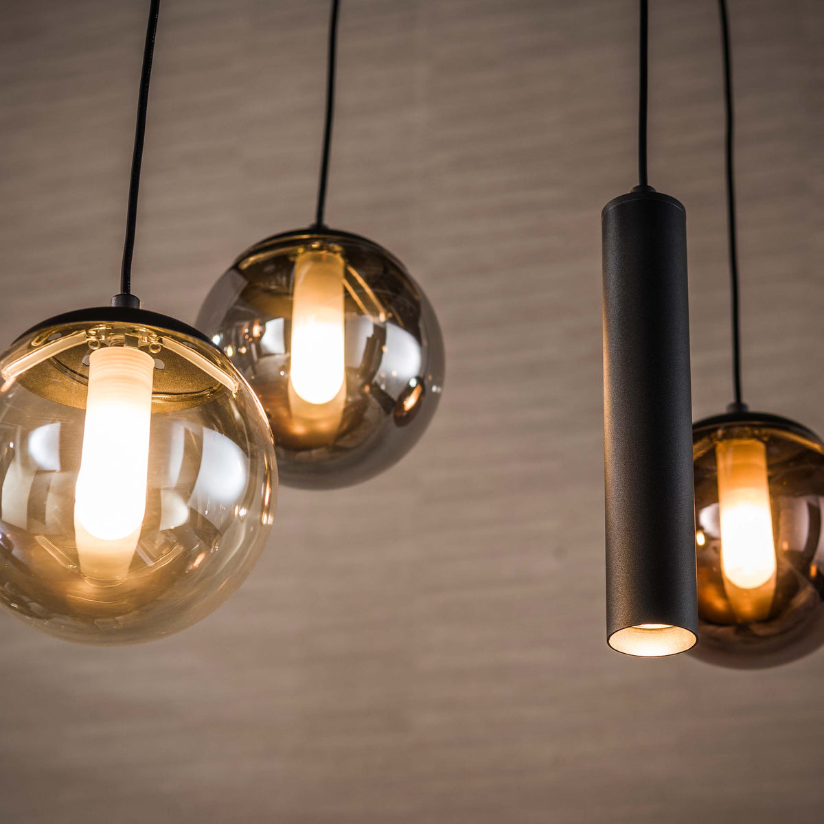Hanglamp Ovio van Meubelista in zwart: detail van een brandende glazen bol en zwarte spot.