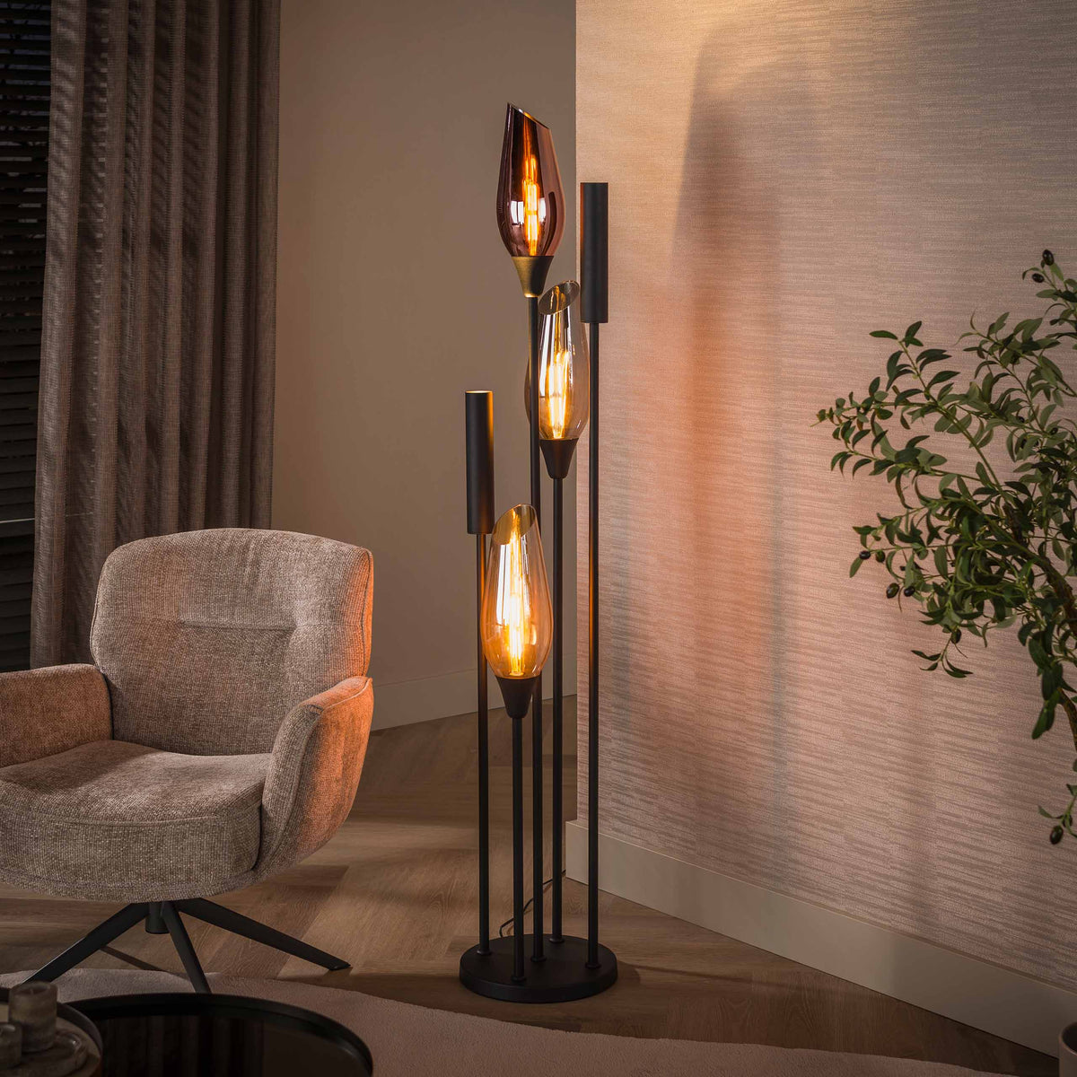 Vloerlamp Alune van Meubelista in zwart: sfeerfoto met glazen kappen en spots verlicht.