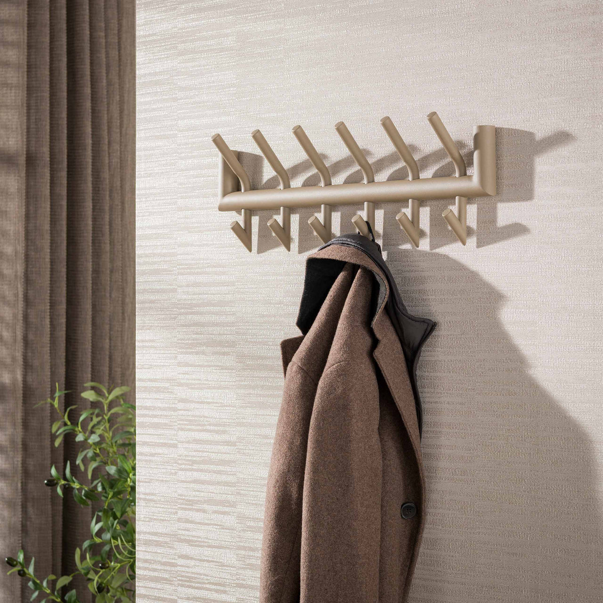 Kapstok Nero van Meubelista in beige: sfeerfoto met jas aan de wand.