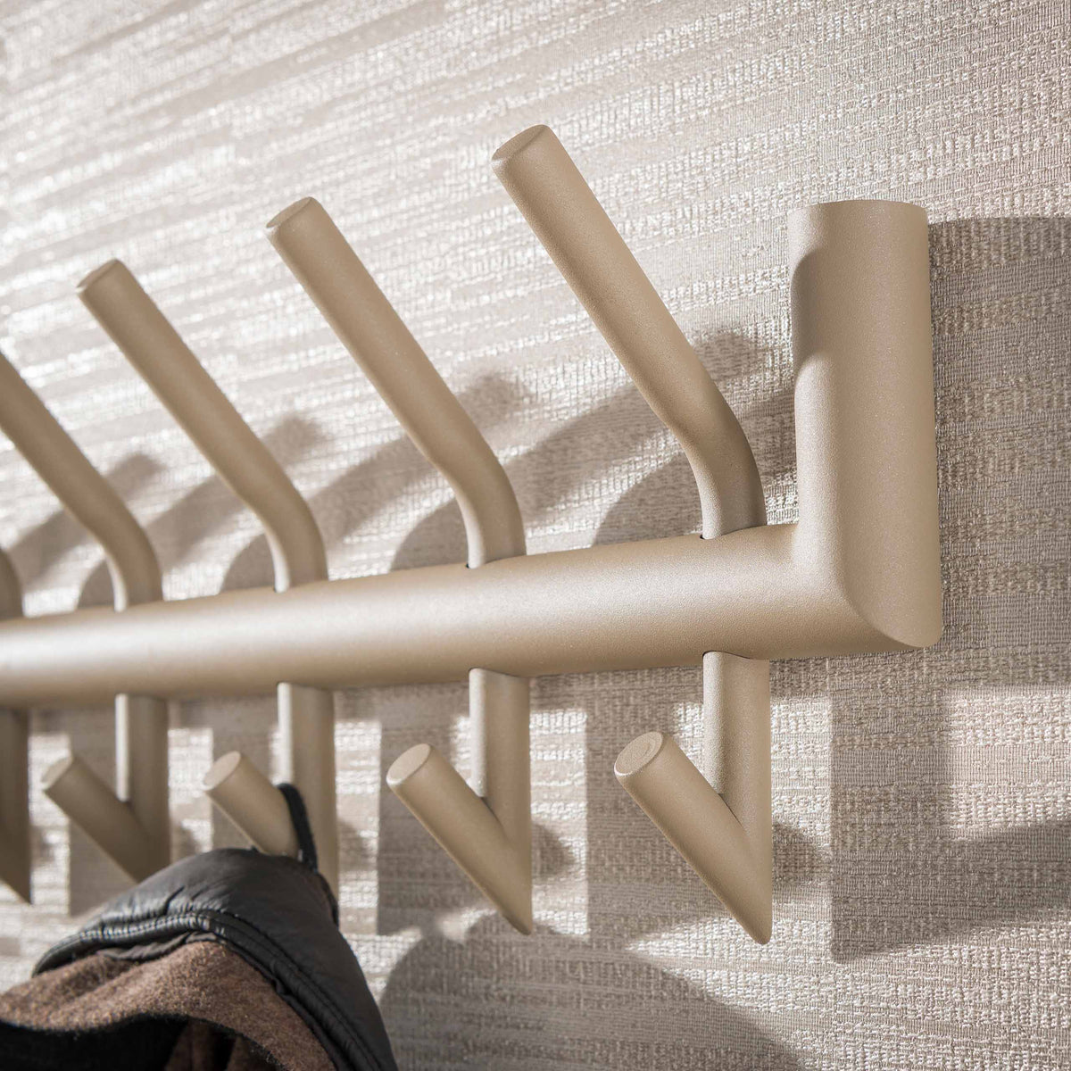 Kapstok Nero van Meubelista in beige: detail van de ronde buis en dubbele haken.