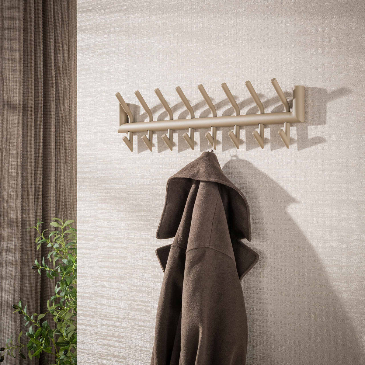 Kapstok Nero van Meubelista in beige: sfeerfoto met jas aan de wand.