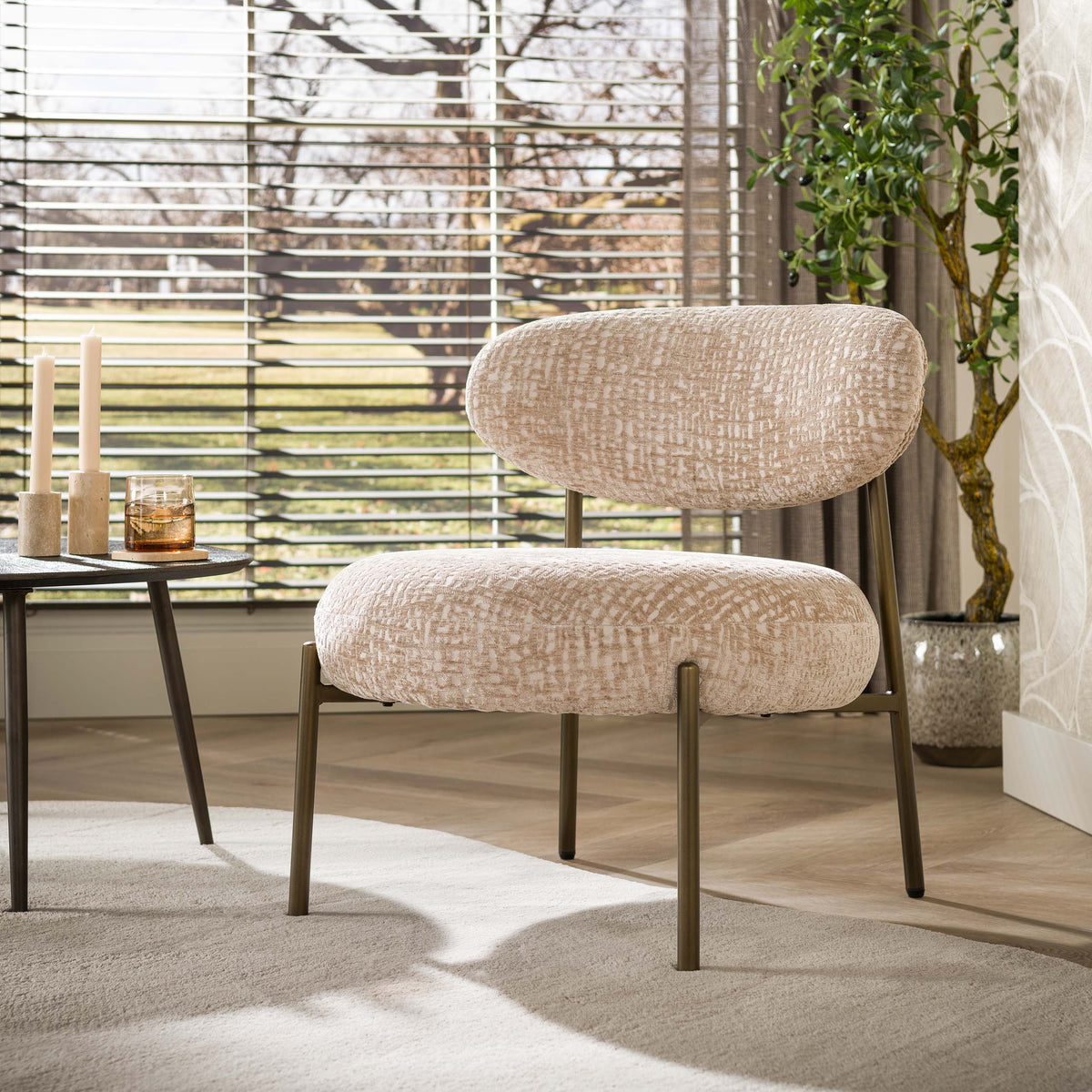 Fauteuil Eluni van Meubelista in beige: sfeerfoto van de fauteuil naast een bijzettafel.