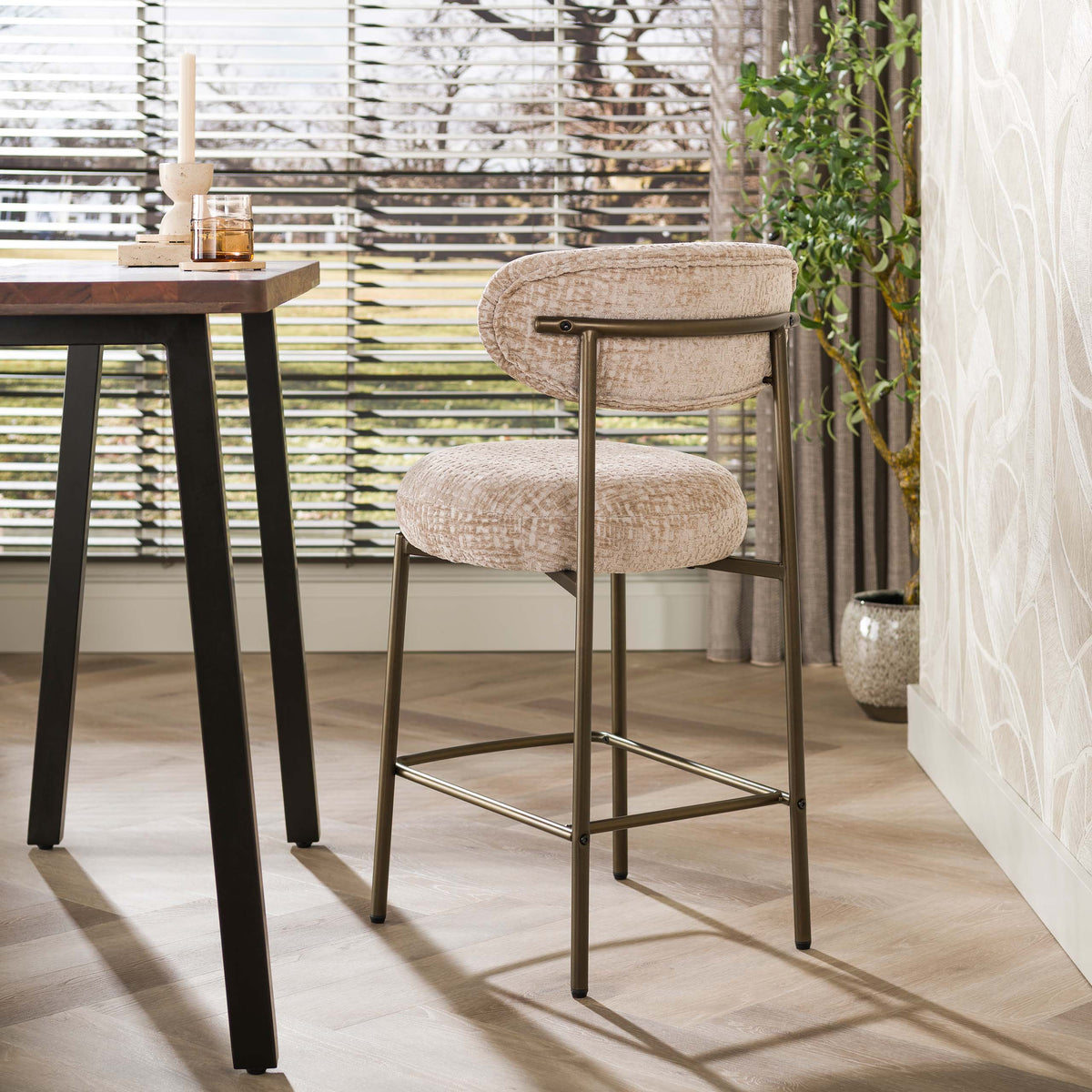 Barstoel Eluni van Meubelista in beige: achteraanzicht bij een hoge tafel.